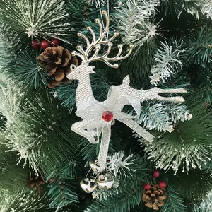 Silver plated reindeer ornament with red gem and heart bells on a snowy Christmas tree