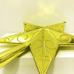 Detailed macro view of a golden Christmas tree topper star featuring elegant engraved patterns