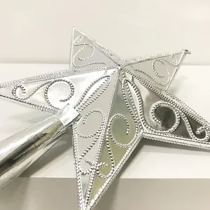 Close-up of silver Christmas tree topper star with decorative wire patterns