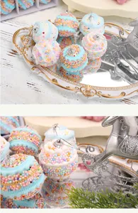 Primer plano de bolas de Navidad macaron con cuentas de colores en una bandeja de espejo.