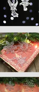 Macro detail of transparent acrylic snowflake and angel Christmas tree ornaments.