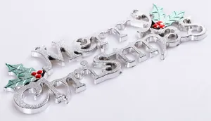 Detailed macro view of a silver Merry Christmas decorative sign with holly leaf accents