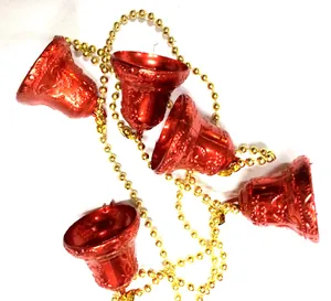 Detalle de campanas de Navidad rojas brillantes unidas por una cadena de perlas doradas festiva.