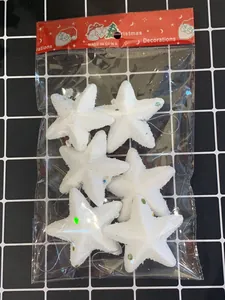 Nahaufnahme von sechs weißen Glitzerschaum-Sternornamenten in transparenter Verpackung.