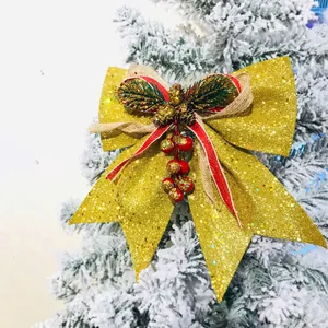 Vista di un fiocco natalizio glitterato oro con pigne e bacche rosse per decorazione