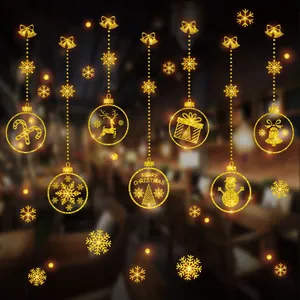 Detail showing golden glitter Christmas window stickers with festive ornament designs