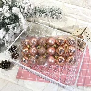 Vista dettagliata di 24 palline di Natale in oro rosa con diverse texture nella confezione.