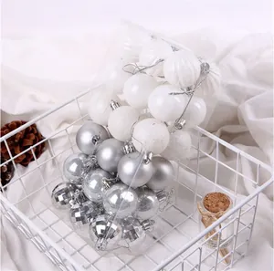 Primo piano di palline di Natale bianche e d'argento in confezione di plastica trasparente