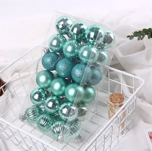 Set di 24 palline di Natale verde acqua con diverse texture in un cesto decorativo bianco