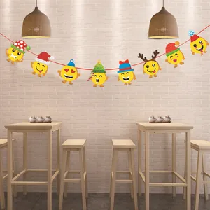 Banderole de Noël avec emojis suspendue contre un mur de briques dans un café