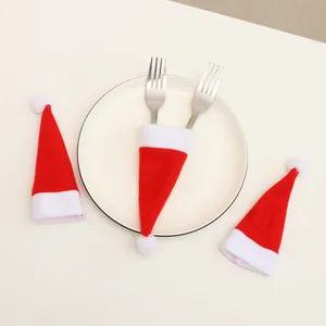 Red velvet mini Santa hat cutlery holders and wine bottle toppers for festive table decor.