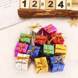 Macro view of colorful miniature metallic Christmas gift box ornaments with gold ties