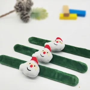Nahaufnahme von drei grünen Plüsch-Weihnachtsmann-Klapparmbändern auf hellgrauem Grund