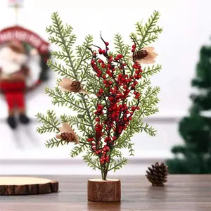Detail van een kunstmatige mini kerstboom met rode bessen en een houten voet