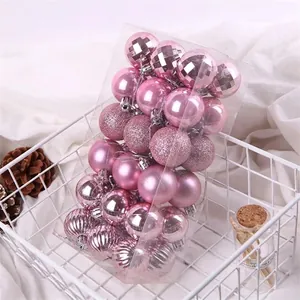 Close-up view of 36 mixed-texture pink Christmas ball ornaments displayed in a white wire basket