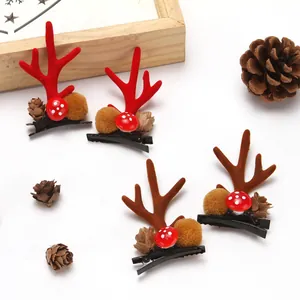 Close-up of cute red and brown reindeer antler hair clips with pinecone details