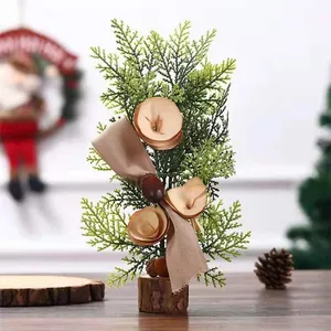 Kleine kunstmatige kerstboom met houten bloemen en lint op een houten boomstronk