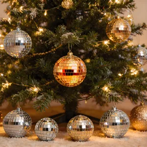 Fonkelende zilveren en gouden discoballen aan een verlichte kerstboom detail