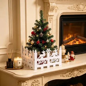 Detailed lifestyle shot of white decorative fence with JOY cutouts around a Christmas tree