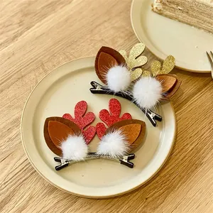 Detailed view of cute red and gold glittery reindeer antler hair clips with fluffy white pom-poms