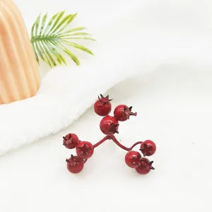 Detailed close-up of glossy artificial red holly berries for Christmas decorations.