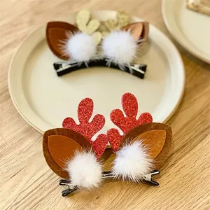 Detailed close-up of cute glittery reindeer antler hair clips with white pom-poms