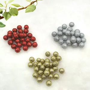 Close-up of glittery decorative berries in red, silver, and gold for festive DIY crafts.