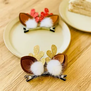 Close-up of glittery reindeer antler hair clips with white pom-poms and felt ears