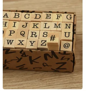 Close-up macro detail of a 40-piece wooden alphabet stamp set in a vintage box.