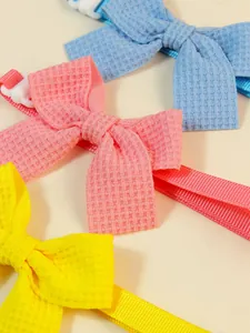 Detailed close-up of colorful waffle fabric pet bow ties with adjustable buckles
