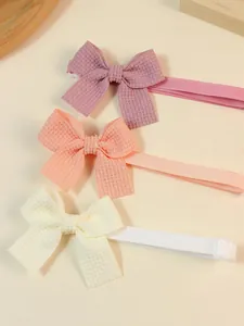Detailed macro view of three waffle-textured pet bow ties in soft pastel colors.