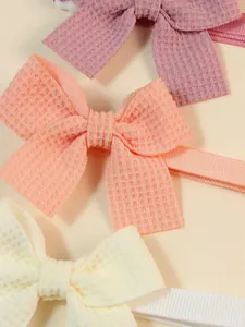 Macro detail showing texture of adjustable waffle fabric pet bow ties in pastel colors.