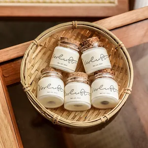 Set of five 20ml scented candle samples in glass jars with cork lids in a bamboo basket