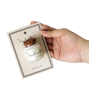 Hand holding a 20ml portable travel size scented candle sample with a cork lid.