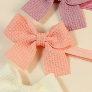 Adjustable waffle fabric pet bow ties in pastel peach, purple, and cream colors