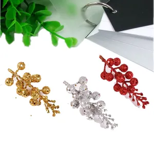Glittering artificial berry branches in gold, silver and red for festive Christmas decor.