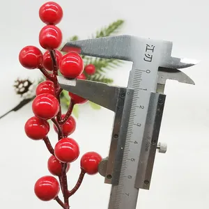 Close-up detail showing measurement of red artificial Christmas berries with a vernier caliper