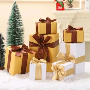 Cajas de regalo de Navidad decorativas en oro y blanco con cintas de seda en entorno festivo