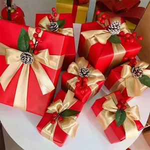 Cajas de regalo decorativas de Navidad rojas con lazos dorados y piñas de pino realistas