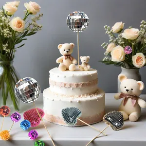 Detailed view of colorful mirror disco ball and heart-shaped cake toppers for party