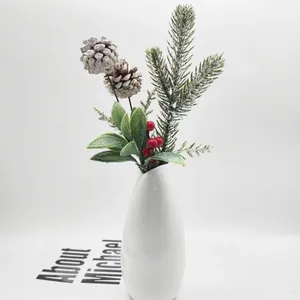 Detailed view of artificial Christmas pine needles with snow-tipped cones and berries