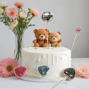 Detail shot showing shiny mirror disco ball cake toppers decorating a birthday cake