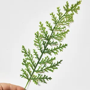 Macro detail of vibrant green artificial PE pine needle branch for Christmas wreath decoration