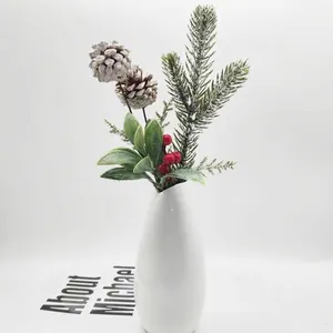 Artificial Christmas pine needle spray with snowy pine cones and red berries in a white vase