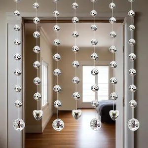 Detail view of silver mirror disco ball strings hanging in a doorway for party decor.