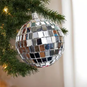 Reflective mirror glass disco ball ornament hanging on a festive Christmas tree