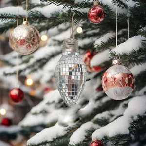Spiegel-Discokugel-Weihnachtsschmuck in Glühbirnenform an einem verschneiten Baum