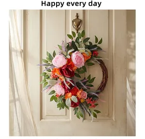 Detail view of decorative pink and orange peony flower wreath hanging on a cream door