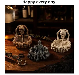 Close-up of gothic Halloween skull and alien resin ashtrays set on dark wooden surface
