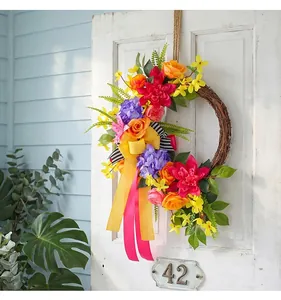 Colorful artificial floral wreath hanging on a white wooden door as a front door decor